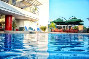 a pool at a hotel with chairs and umbrellas at Hotel Atrium Plaza in Barranquilla