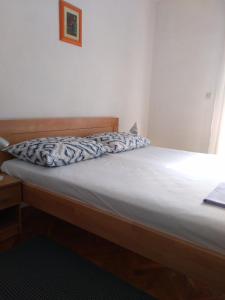 a bed in a room with a white bedsheet at Room Rade in Stari Grad