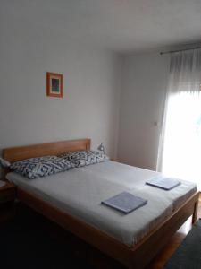Un dormitorio con una cama con dos libros. en Room Rade en Stari Grad