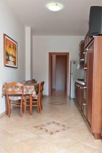 ein Wohnzimmer mit einem Tisch und einer Küche in der Unterkunft Il Rifugio di Giada e Mattia in Alberobello