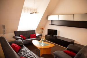 a living room with two couches and a tv at Hotel Wappenstube in Erbach im Odenwald