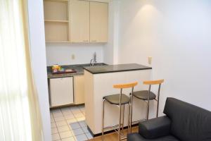 a kitchen with a table and chairs and a refrigerator at San Diego Convention Lourdes in Belo Horizonte