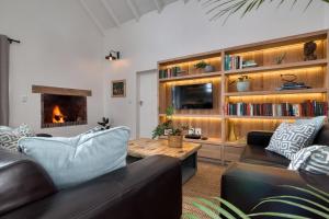 a living room with a couch and a table and a fireplace at Amia House Struisbaai in Struisbaai