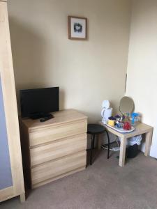 a room with a desk with a television and a desk with a mirror at The Townhouse B and B in Aylesbury
