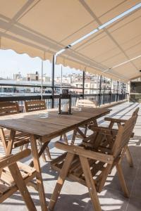 a wooden table with chairs and an umbrella on a roof at Cataleya #colony city center in Thessaloniki