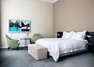 een slaapkamer met een groot wit bed en een stoel bij Pillows Grand Boutique Hotel Ter Borch Zwolle in Zwolle