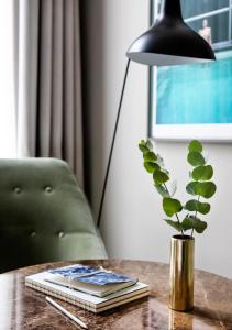 een tafel met een lamp en een vaas met een plant bij Pillows Grand Boutique Hotel Ter Borch Zwolle in Zwolle