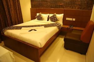 ein Hotelzimmer mit einem Bett und einem Stuhl in der Unterkunft Horizon Inn in Chennai