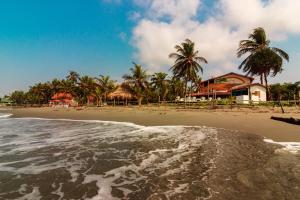 a view of a beach with houses and palm trees at Santa María de los Vientos in San Bernardo del Viento