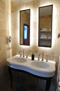a bathroom with two sinks and a mirror at Les Chambres De La Renaissance in Sainte-Julie