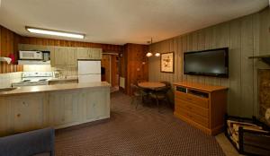 a kitchen with a tv and a table with a counter at Douglas Fir Resort & Chalets in Banff