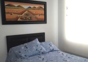 1 dormitorio con 1 cama con una foto en la pared en Casa Quinta familiar piscina privada Girardot, en Girardot