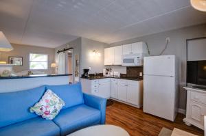 a living room with a blue couch and a kitchen at Matanzas Inn in Fort Myers Beach