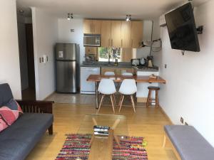 a living room with a table and a kitchen at Departamento 501 in Pucón