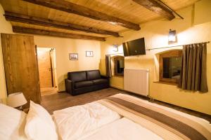 - une chambre avec un lit et un canapé en cuir dans l'établissement Gorska Reka Guesthouse, à Zreče