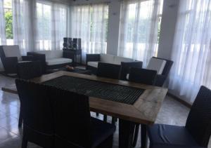 a dining room with a table and chairs and windows at Casa Quinta con piscina privada Girardot in Girardot