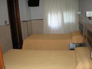 Posteľ alebo postele v izbe v ubytovaní Hostal La Hispanidad