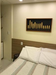 ein Schlafzimmer mit einem Bett mit einem hölzernen Kopfteil in der Unterkunft Praia do Forte Apt. in Praia do Forte