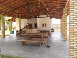 a pavilion with wooden tables and chairs in a building at Orla Piaui in Luis Correia