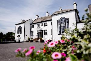 a white building with flowers in front of it at Gretna Hall Hotel in Gretna Green