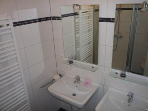 a white bathroom with a sink and a mirror at Borkumperle in Borkum