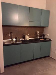 una cocina con armarios azules y fregadero en Casa Ettolina al Campus Einaudi, en Turín