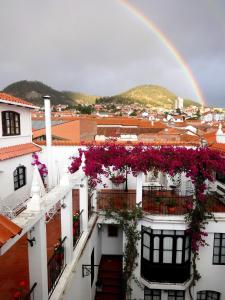 un arco iris sobre una ciudad con un edificio con flores en El Hotel de Su Merced, en Sucre