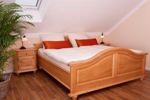 a bedroom with a wooden bed with two night stands at Pension Weindl in Notzing