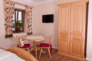 a room with a table and chairs and a bed at Pension Weindl in Notzing