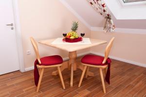 a table with two chairs and a bowl of fruit at Pension Weindl in Notzing