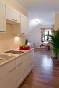 a kitchen with white cabinets and a table with fruit on the counter at Pension Weindl in Notzing
