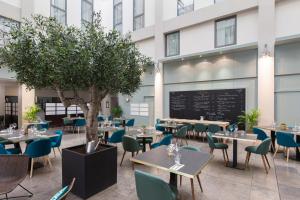 a restaurant with tables and chairs and a tree at Appart'City Classic Lyon Part-Dieu in Lyon