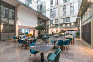 un restaurant avec des tables et des chaises et un bâtiment dans l'établissement Appart'City Classic Lyon Part-Dieu, à Lyon