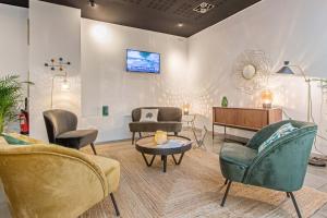 a living room with chairs and a couch and a tv at Appart'City Classic Lyon Part-Dieu in Lyon
