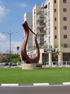 a sculpture sitting in the grass in front of a building at The Shining Star -A beautiful 3 bedroom apartment in Beer Sheva +33 photos