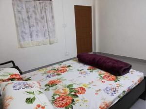 a bed with a floral comforter on top of it at Delight Homestay in Cherrapunji