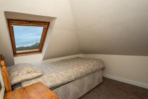 a small bedroom with a bed and a window at Clara Lodge Guesthouse in Dunfermline