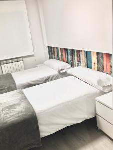 two beds sitting next to each other in a bedroom at W W W GoyaHospitales es Bajo B in León