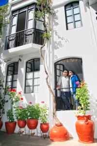 two people standing in the window of a building at El Hotel de Su Merced in Sucre