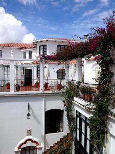 a white building with flowers on the balconies at El Hotel de Su Merced in Sucre