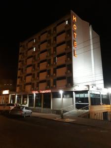 a building with a sign on the side of it at night at Hotel Vivendas Centro in Erechim