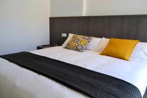 Una gran cama blanca con almohadas amarillas. en Hotel Alda Estación Ourense, en Ourense 37 fotos más