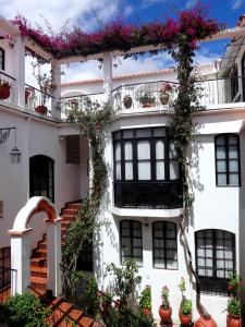 un edificio blanco con flores en los balcones en El Hotel de Su Merced, en Sucre