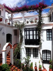 un edificio blanco con flores en los balcones en El Hotel de Su Merced, en Sucre 37 fotos más