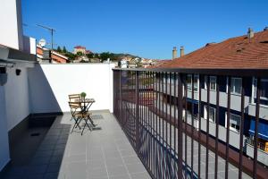 Un balcón con una mesa y sillas en un edificio. en Hotel Alda Estación Ourense, en Ourense