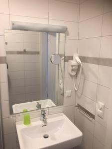 a white bathroom with a sink and a mirror at Bergschlößchen in Jüterbog