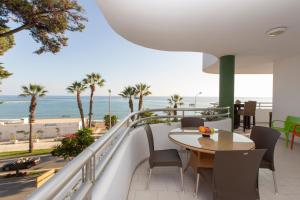 een balkon met een tafel en uitzicht op het strand bij Villa Venecia, Apartamento de Lujo en 1º línea de playa + parking in Málaga