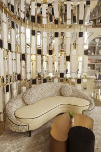 um banco numa sala com uma parede de espelhos em Hôtel le Derby Alma by Inwood Hotels em Paris