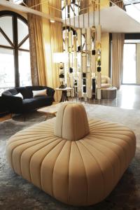 a living room with a large ottoman in the middle at Hôtel le Derby Alma by Inwood Hotels in Paris