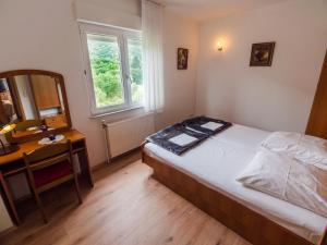 ein Schlafzimmer mit einem Bett, einem Schreibtisch und einem Spiegel in der Unterkunft 689 Banjol in Rab